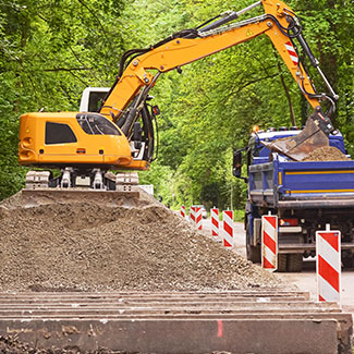 Excavatrice jaune déplaçant de la terre dans un camion