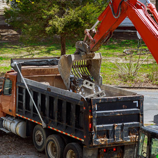 Excavatrice met des matériaux dans un camion